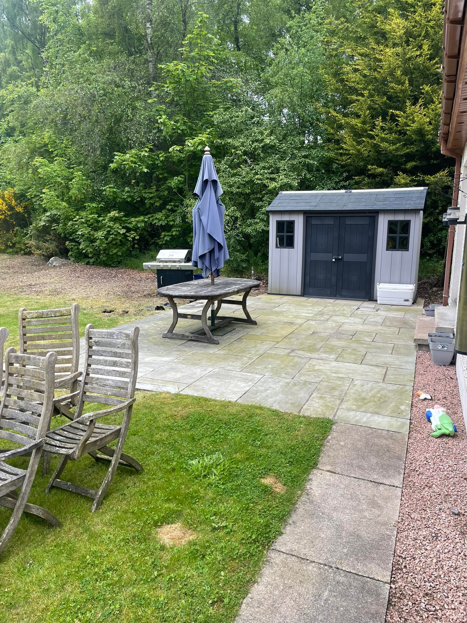 Clean slabbed garden patio with shed and seating in Aberdeenshire